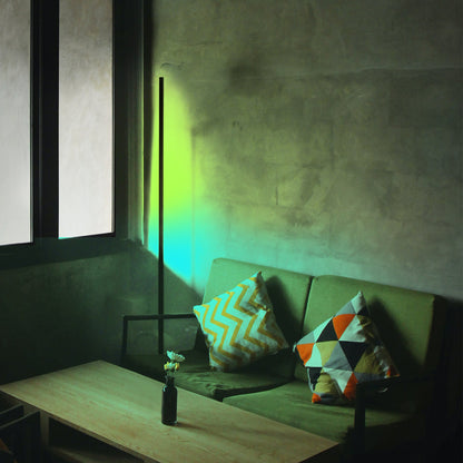 Green sofa with colorful cushions in a dimly lit room with a lamp casting a green glow with cornor lamp.