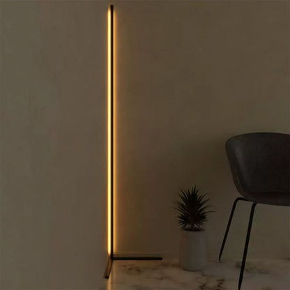 Modern floor lamp with a vertical light strip in a minimalistic room.
